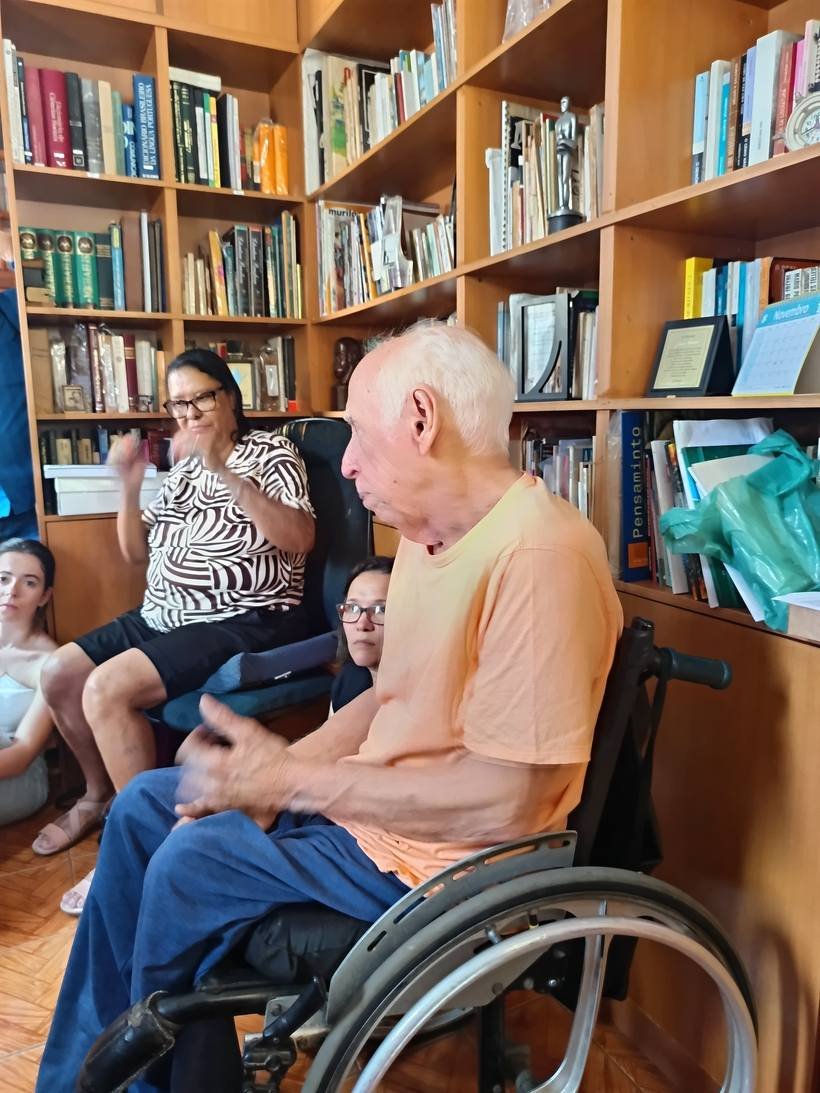 Voluntária acompanhando morador na biblioteca